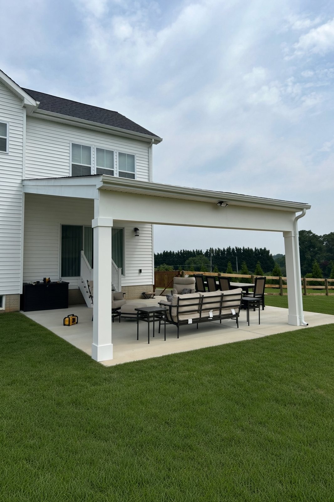 White covered patio on a new concrete pad with outdoor furniture