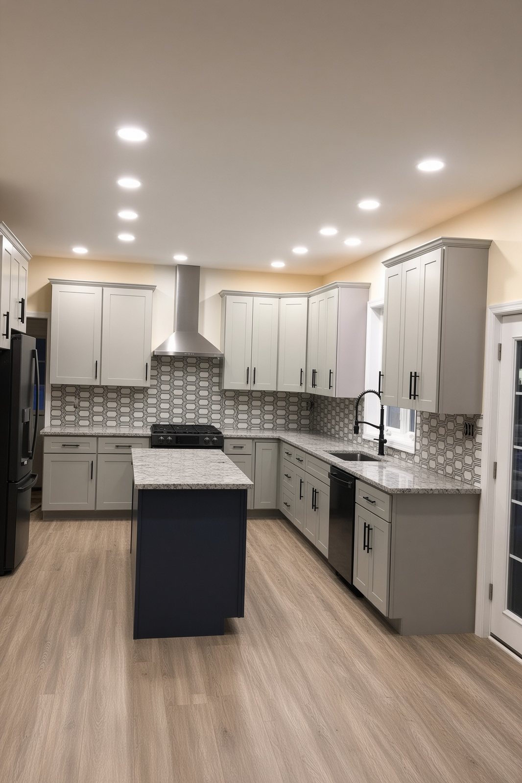 Gray kitchen with geometric tile backsplash, an island, and a stainless range hood