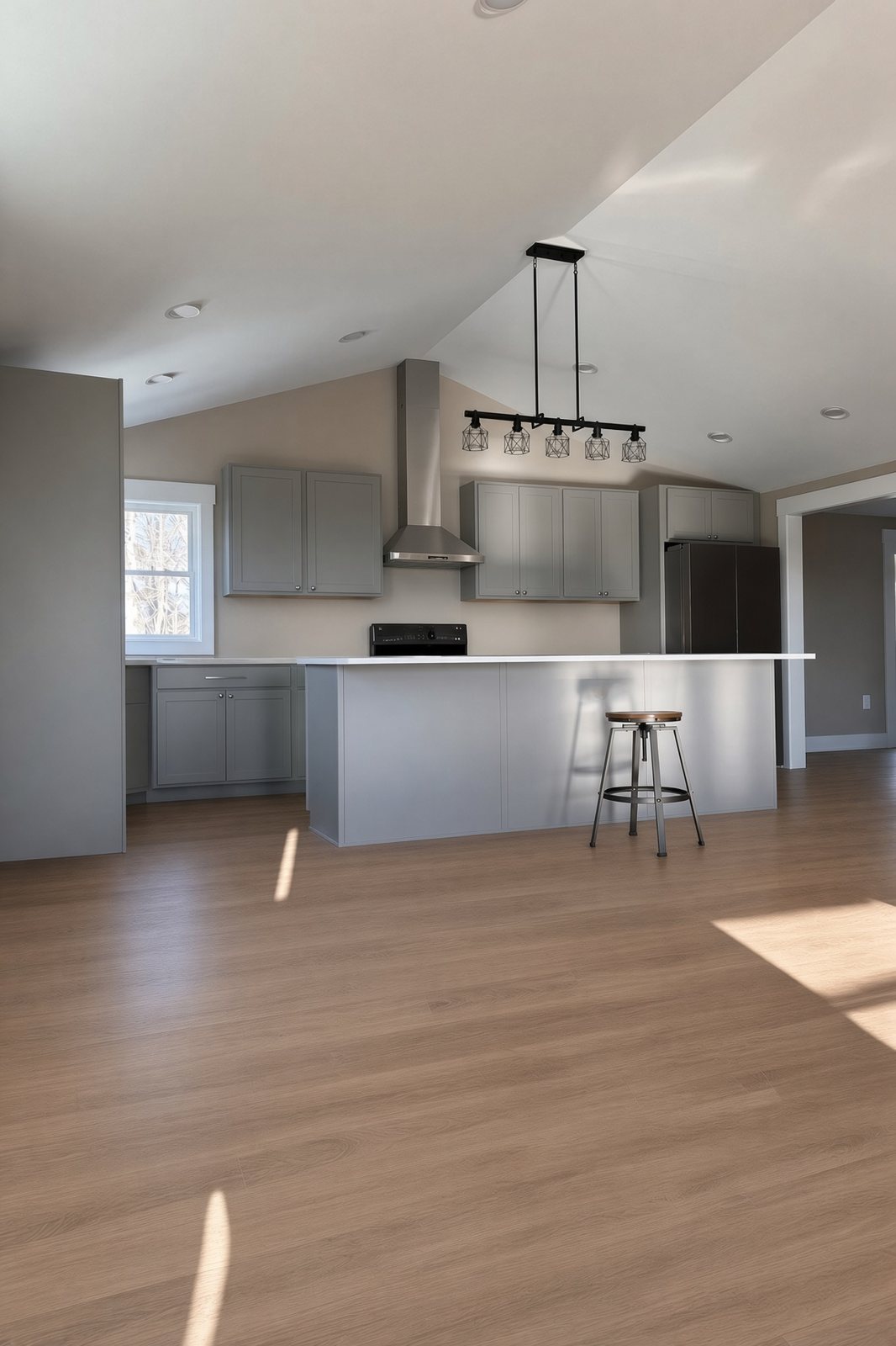 Gray kitchen with a large island, pendant lights, and wide-plank floors