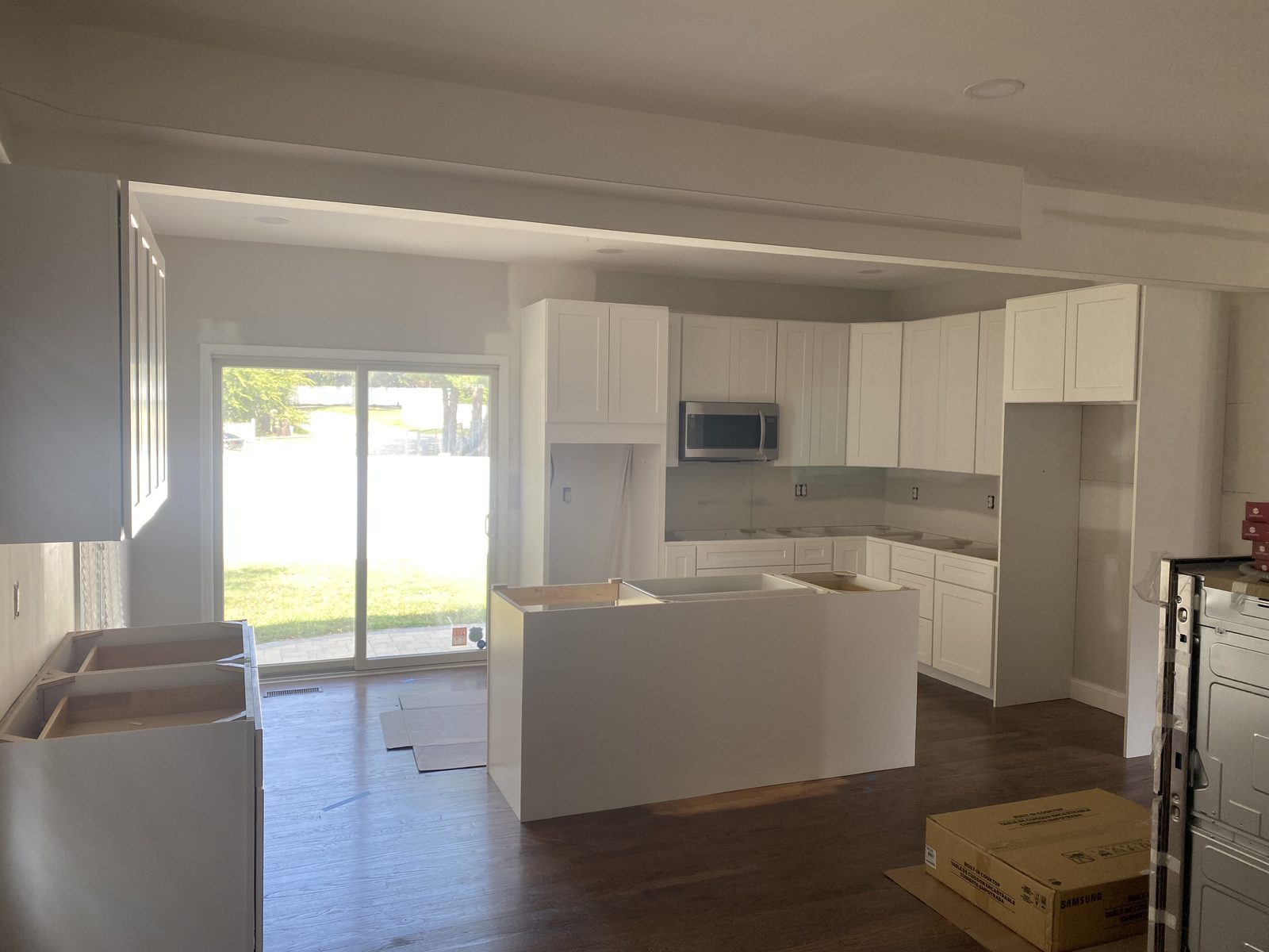 White kitchen cabinets set with a new island and sliding doors beyond