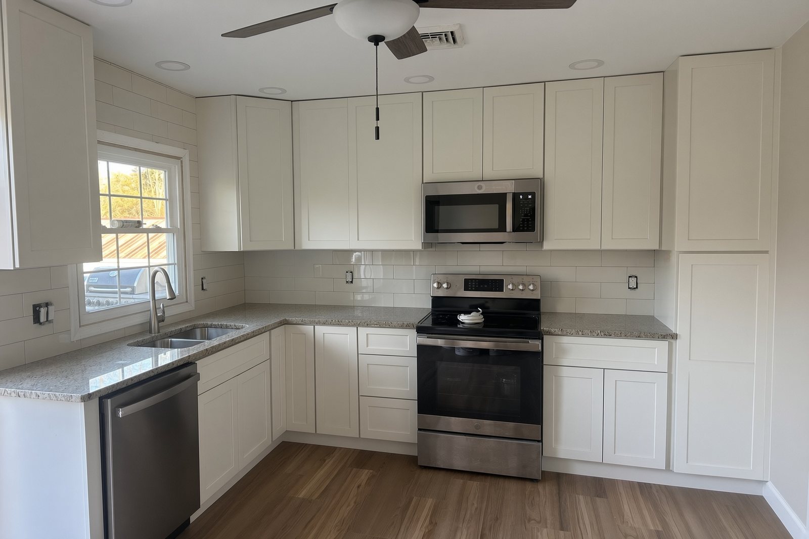 Cream shaker kitchen with subway tile, granite, and stainless appliances