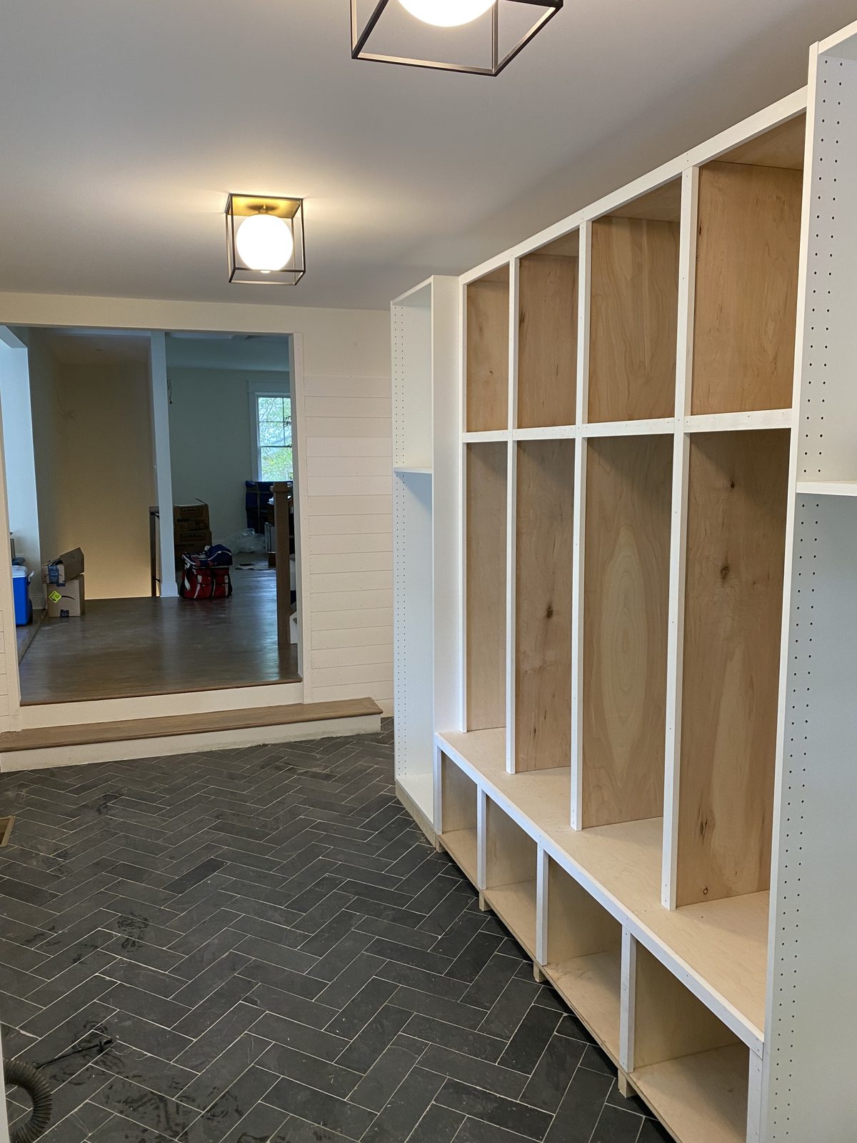 Mudroom lockers being built over a herringbone slate floor