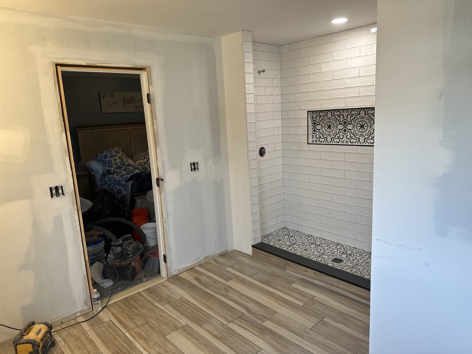 Same patterned shower being tiled, before glass