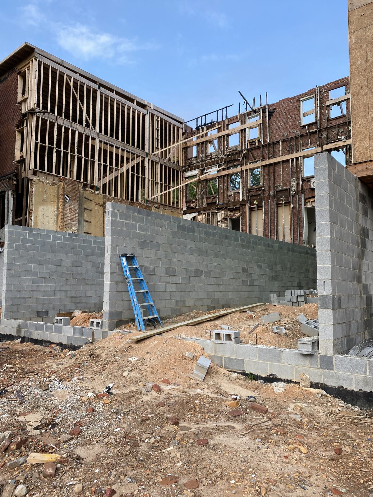 New concrete-block foundation walls under a house being reframed after a fire