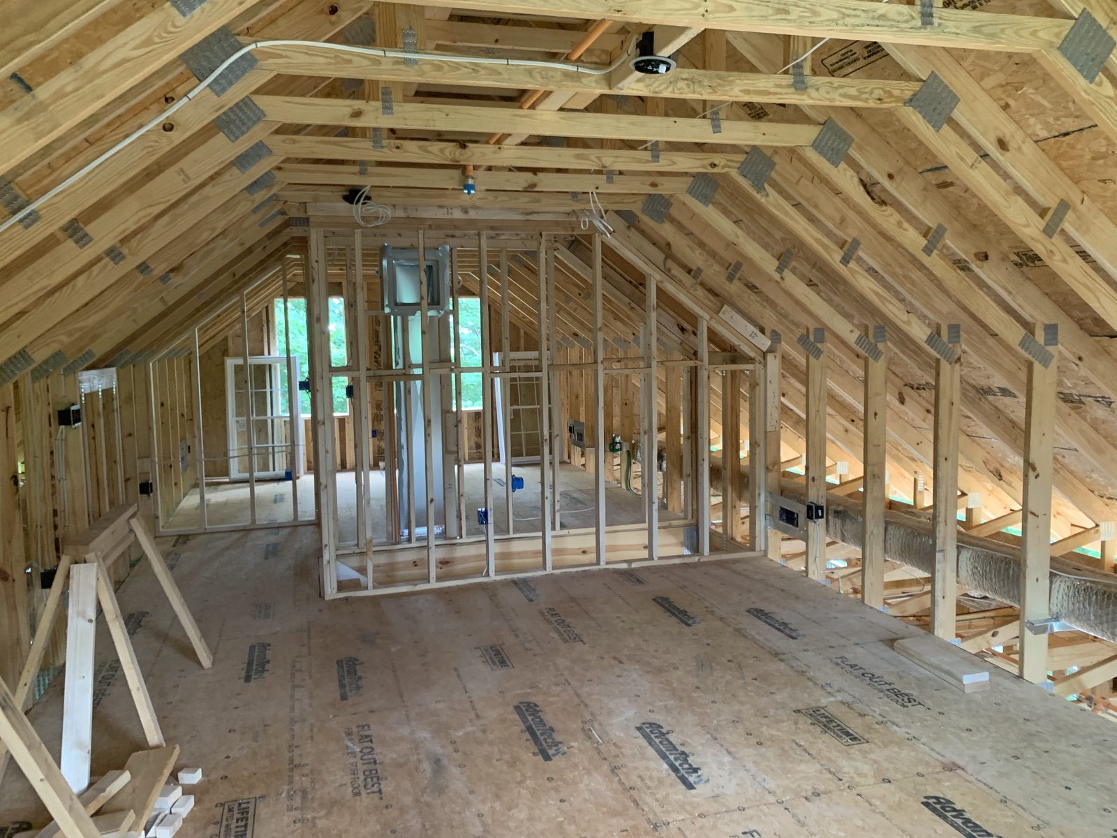 Second-floor rooms framed under a vaulted roof with windows set