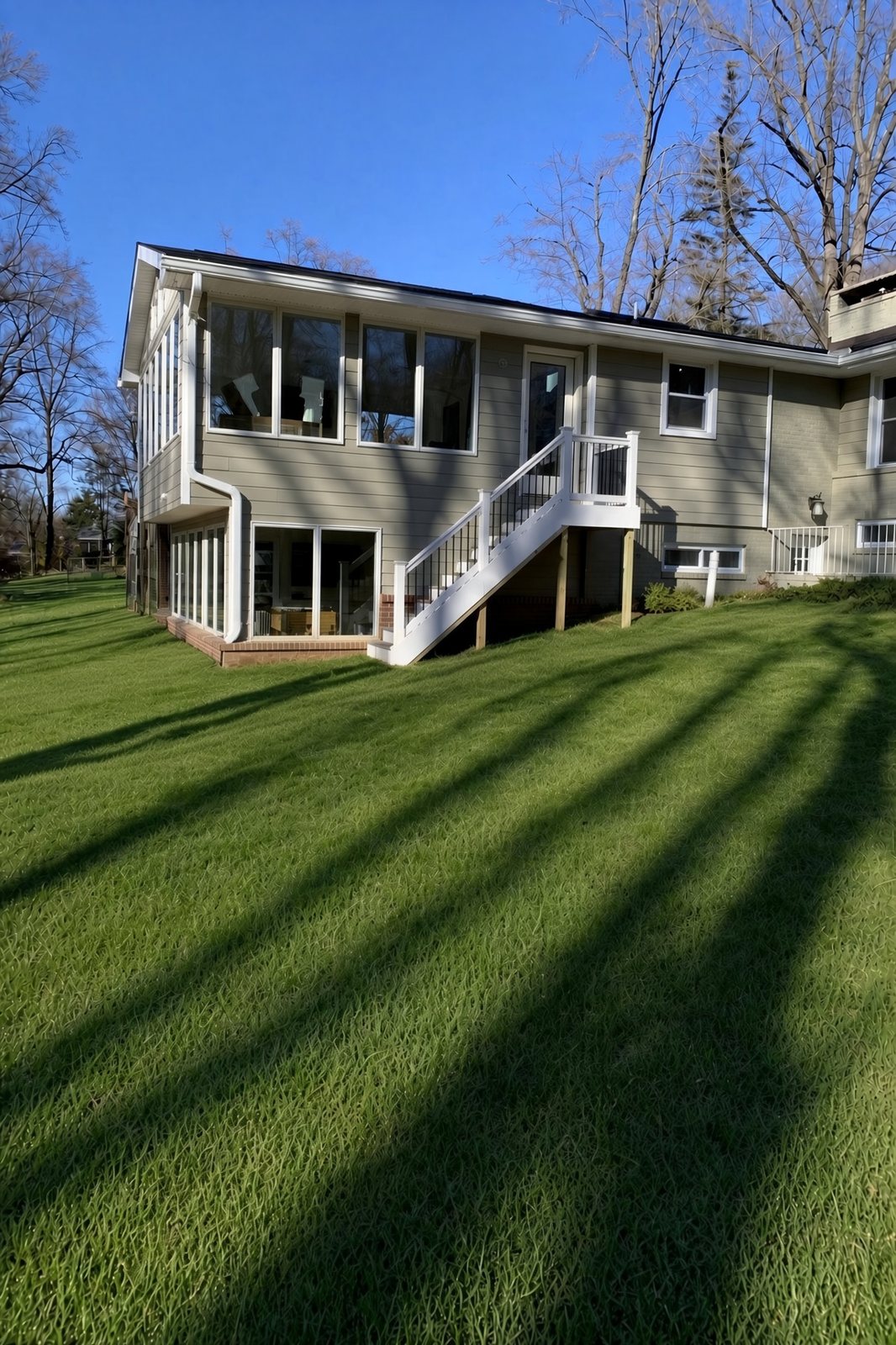 Finished sunroom addition with a white stair and railing on the side